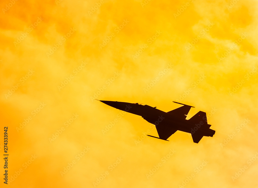 Silhouette falcon fighter jet military aircraft flying on sunset ...