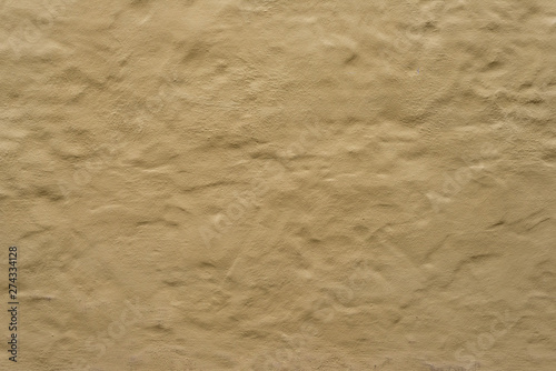 Rough bumpy brown yellow concrete plaster stucco texture or surface background.