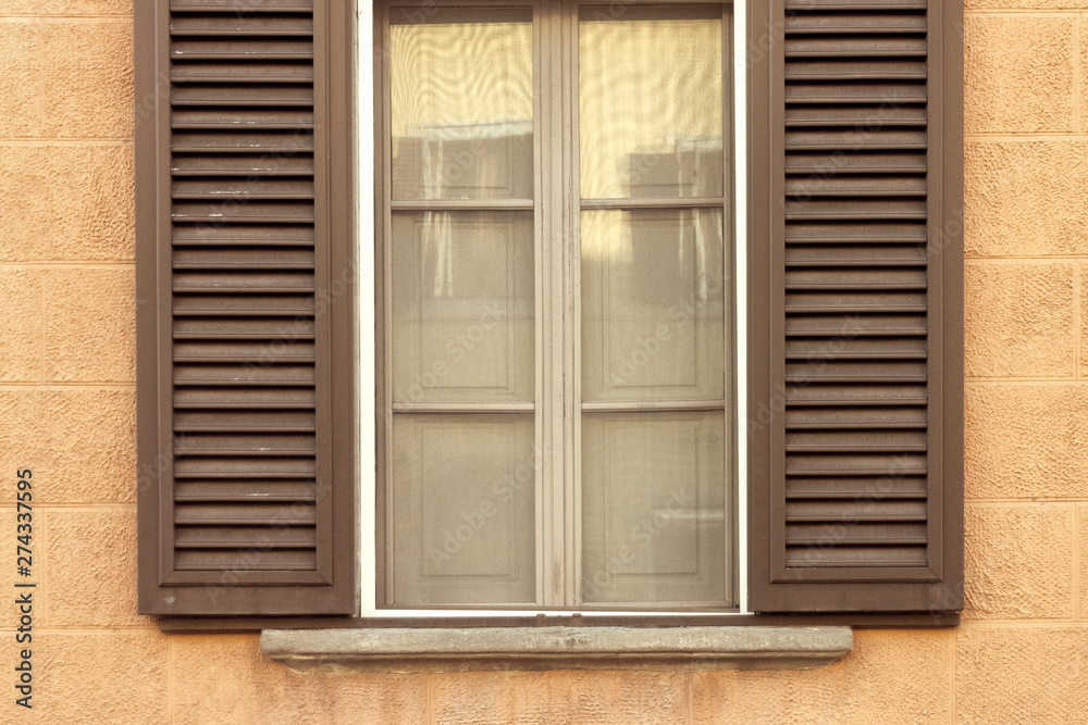 brown wooden window with shutters on yellow textural wall brown wooden window with shutters on yellow textural wall