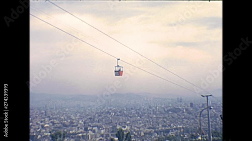 cableway moving on top of skyline of Barcelona city from the Montjuic Castle, an old military fortress of Catalonia region overlooking Barcelona. Historical archival of aerial view of Spain in 1970s. photo