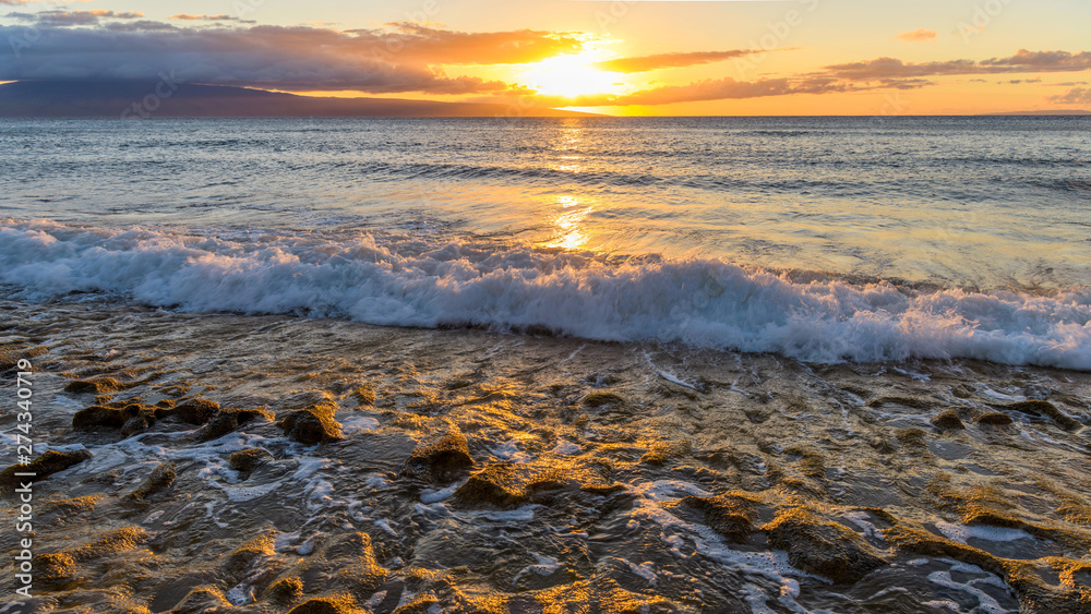 Naklejka premium Ocean Sunset - Colorful sunset view of strong waves rushing into a rocky beach at north-west coast of Maui island, Hawaii, USA.