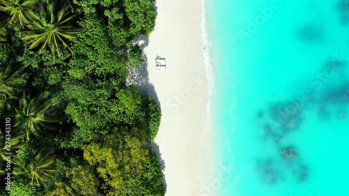 aerial drone overhead shot over the Jamaica island with white sand beach and two sunbeds, ideal tropical honeymoon destination photo