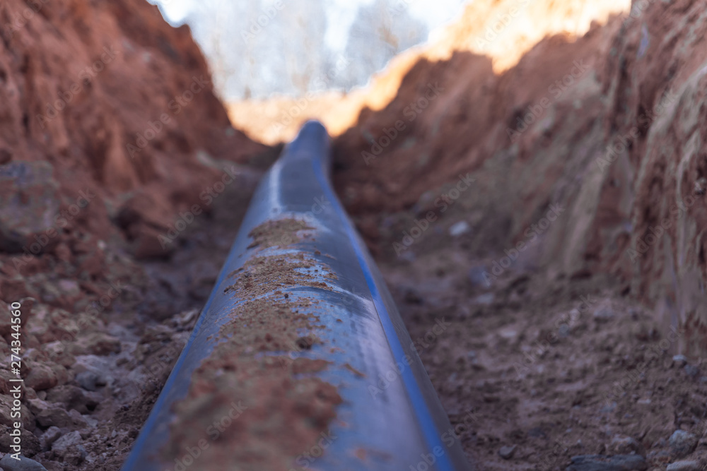 Fototapeta premium Plastic water pipe lay in a trench