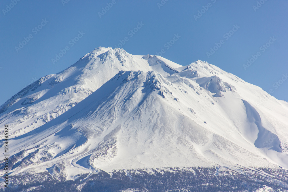 Mount Shasta covered in snow in a blue sky