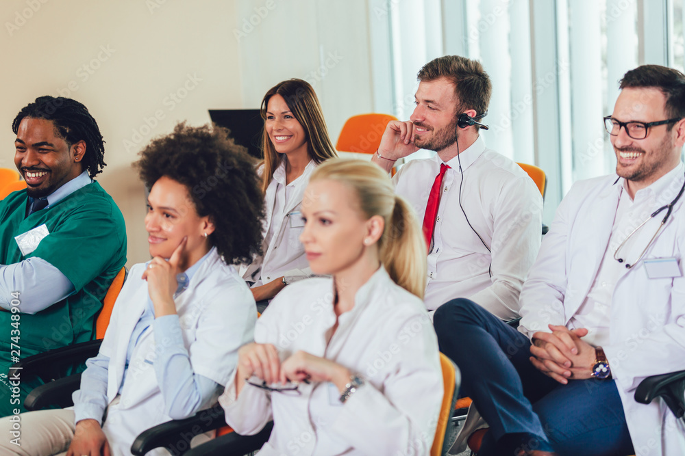 Group of happy doctors on seminar in lecture hall at hospital Group of happy doctors on seminar in lecture hall at hospital
