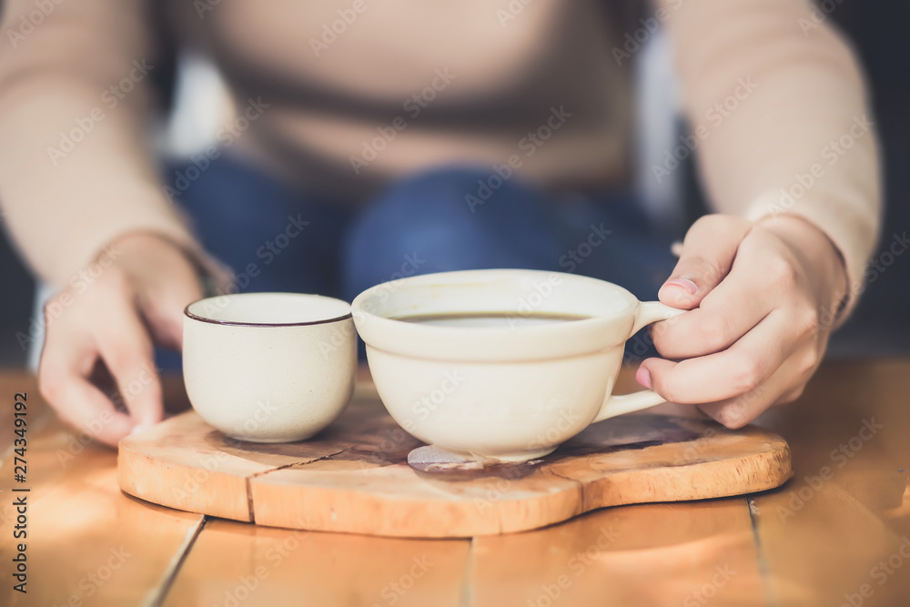 Young woman holding a cup of hot coffee in nature view Young woman holding a cup of hot coffee in nature view