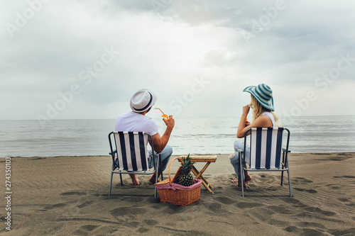 Vászonkép Couple on a deck chair relaxing on the beach