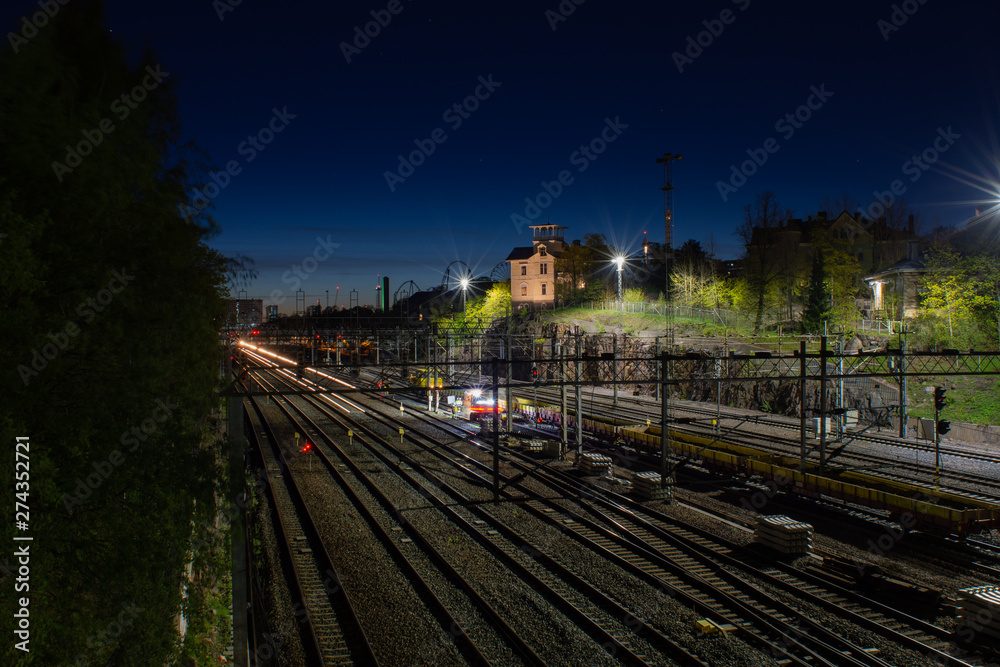 Fototapeta premium Helsinki cityscape and railtracks by night at Linnunlaulu overpass