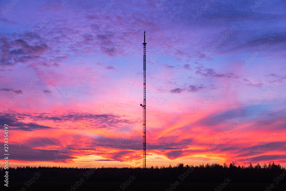 Telecommunication tower on a background of pink sunset