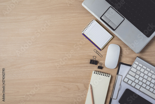 Workspace with diary or notebook and clipboard, laptop, mouse computer, keyboard, smart phone, pencil, pen on wooden background
