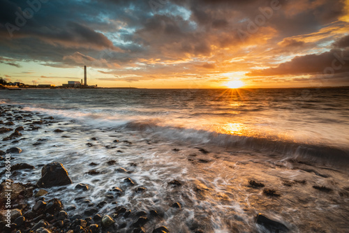 Dawn on Downshire Beach, Carrickfergus, Northern Ireland with Kilroot Power Station in the distance. photo