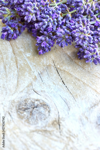 Lavender flowers in deep purple or lilac on old weathered wooden background with copy space. Vertical image