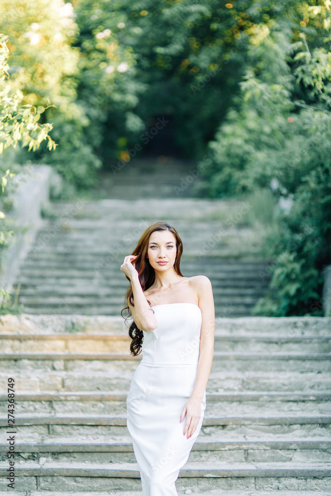 Summer photo shoot in the Park at the rocks and stones. Beautiful girl in white dress and hat. Summer photo shoot in the Park at the rocks and stones. Beautiful girl in white dress and hat.