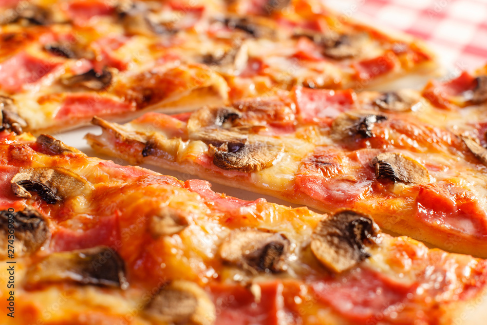 Pizza with ham and mushrooms. Delicious hot food sliced and served on white platter. Menu photo, Italian fast food.