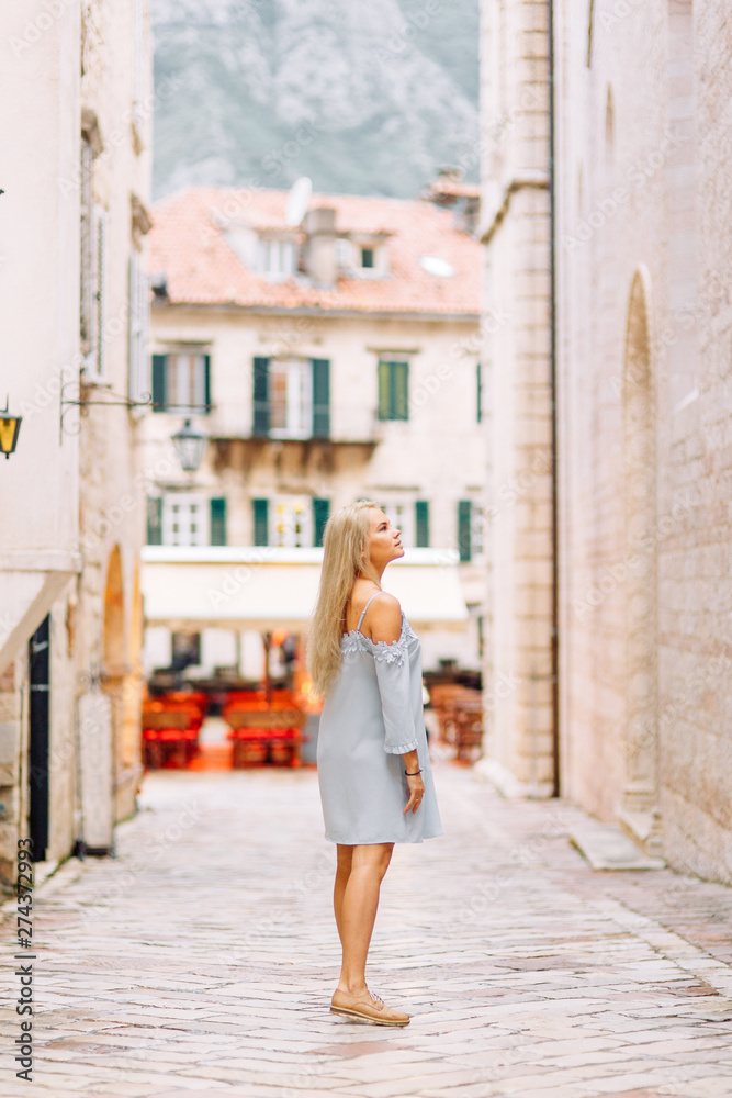 Beautiful girl with lights in Montenegro. Photo shoot on the evening and night streets of Kotor.