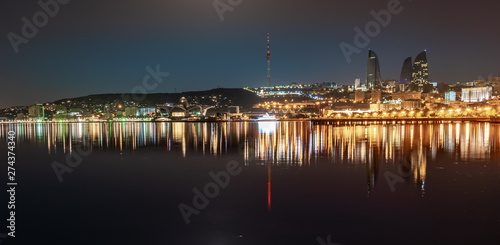 Baku Azerbaijan - 16 June, 2019. Reflection of the lights of the night city in the caspian sea. Night view of Baku with the Flame Towers skyscrapers
