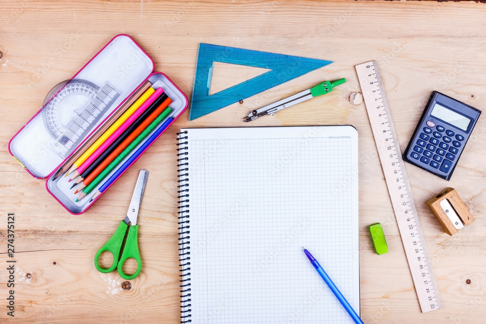 Back to school concept. Flat lay of stationery for the student - scissors, sharpener, eraser and white notebook. Back to school concept. Flat lay of stationery for the student - scissors, sharpener, eraser and white notebook.