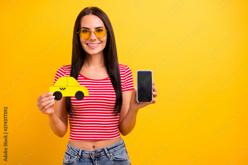 Portrait charming student lady weekend hold hand paper card taxi touch screen isolated leisure long haircut trendy eyeglasses eyewear yellow background denim jeans red striped stylish t-shirt she her - obrazy, fototapety, plakaty 