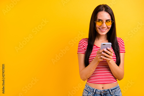 Portrait of nice pretty creative student blogger use user device have dialogue conversation eyewear eyeglasses dressed denim jeans outfit isolated yellow background she her bright