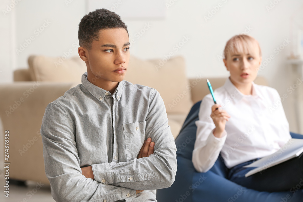 Female psychologist working with teenage boy in office Female psychologist working with teenage boy in office