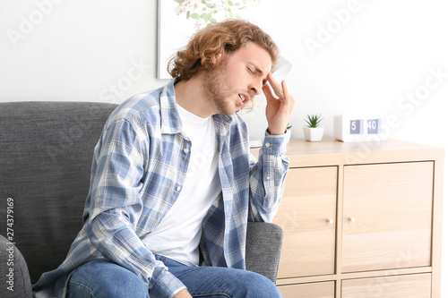 Young man experiencing head...