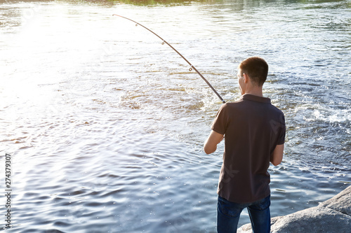 Young man fishing in river