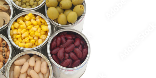 Many canned food: green peas, beans, corn, olives and mushrooms in tin cans isolated on white background.