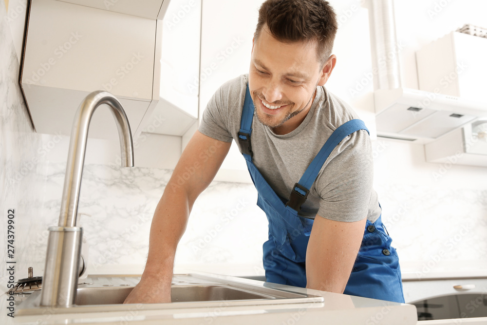 Plumber installing sink in kitchen Plumber installing sink in kitchen