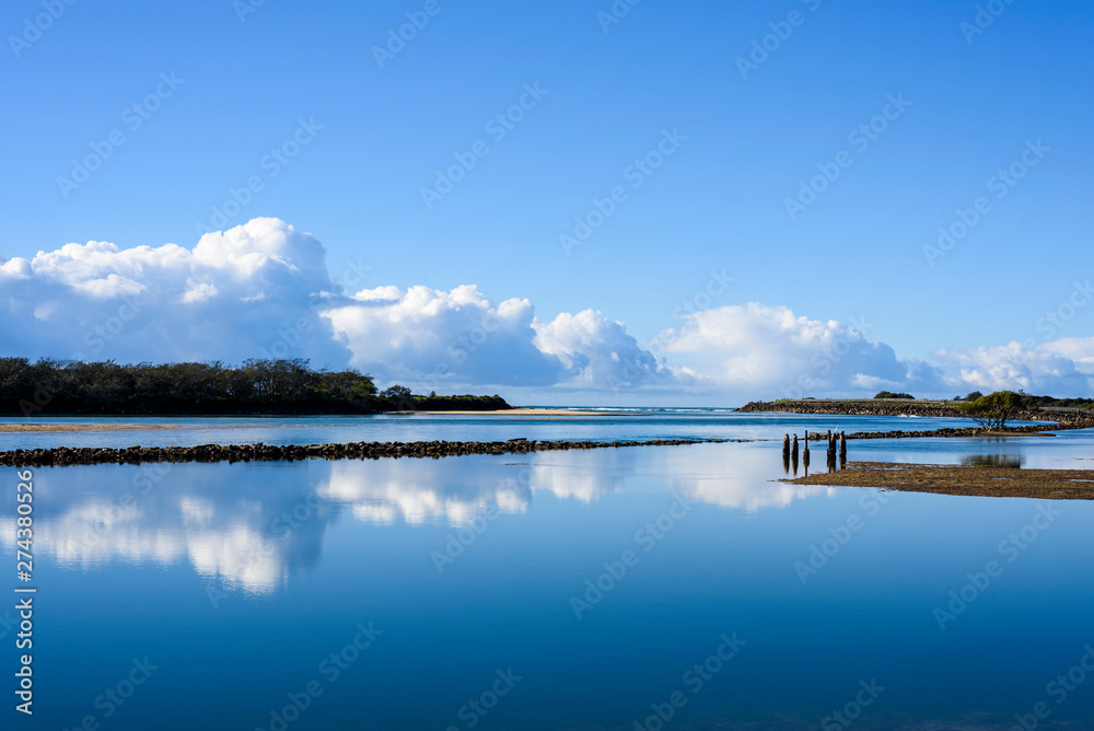 Scenic landscape with lagoon and trees, reflections in the water.