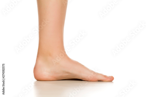 Side view of female bare foot on white background