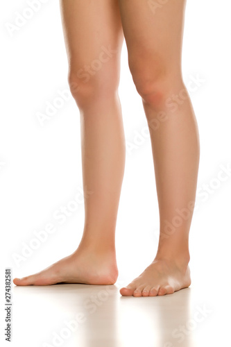 Side view of female barefoot legs on white background © Jasmina