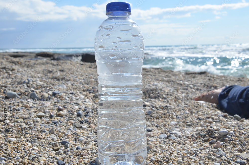 Pure sparkling water ad, plastic bottle with splash on snow with sea or ocean mountain background. Transparent Drinking water liquid Bottle design.