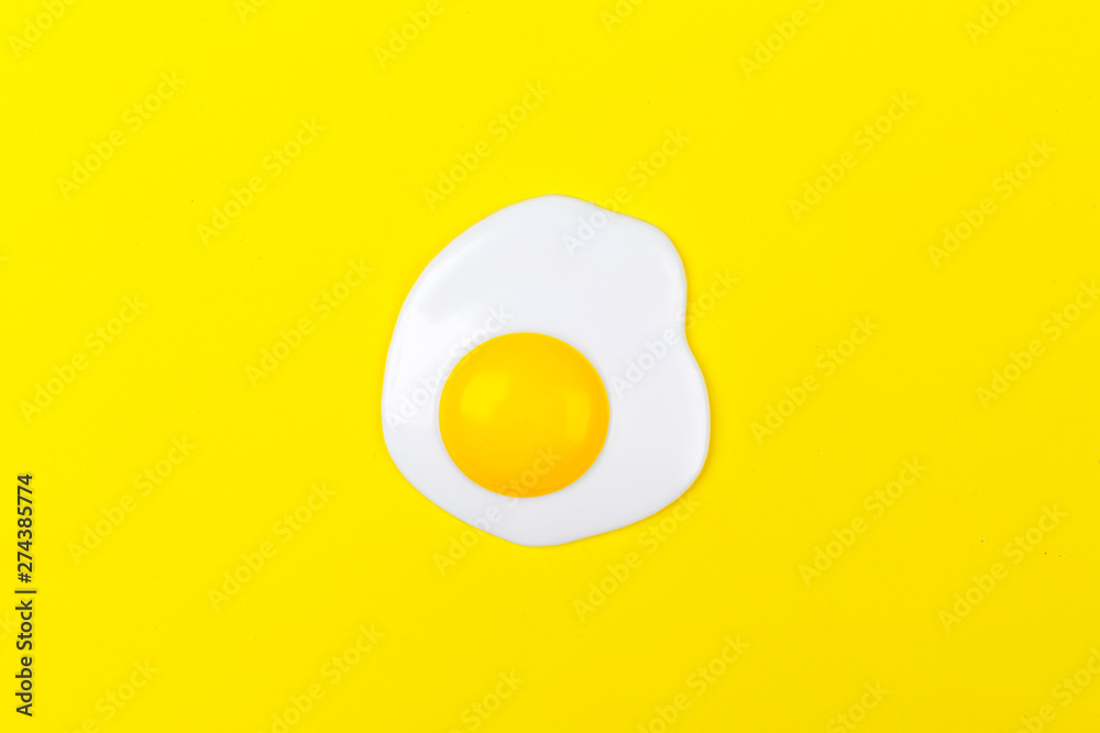 Fried egg on a yellow background. Flat lay, top view Fried egg on a yellow background. Flat lay, top view