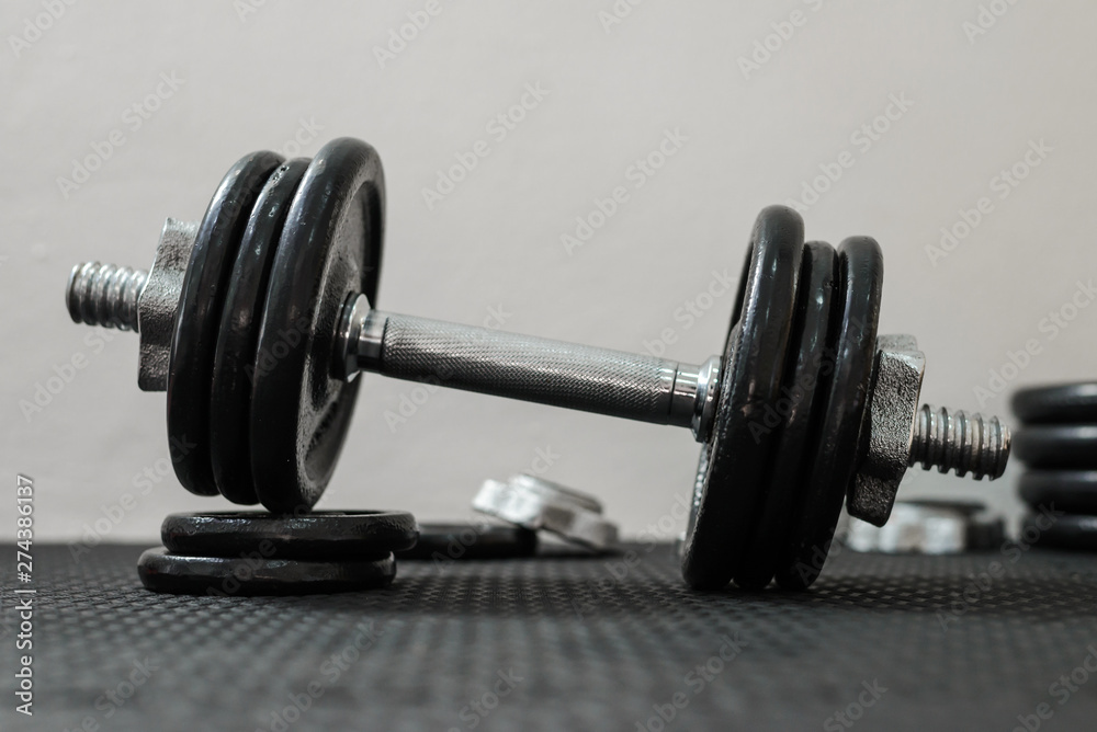Fototapeta premium Iron dumbbells or weights on black floor in the gym. Weight Training Equipment. Health care concept.
