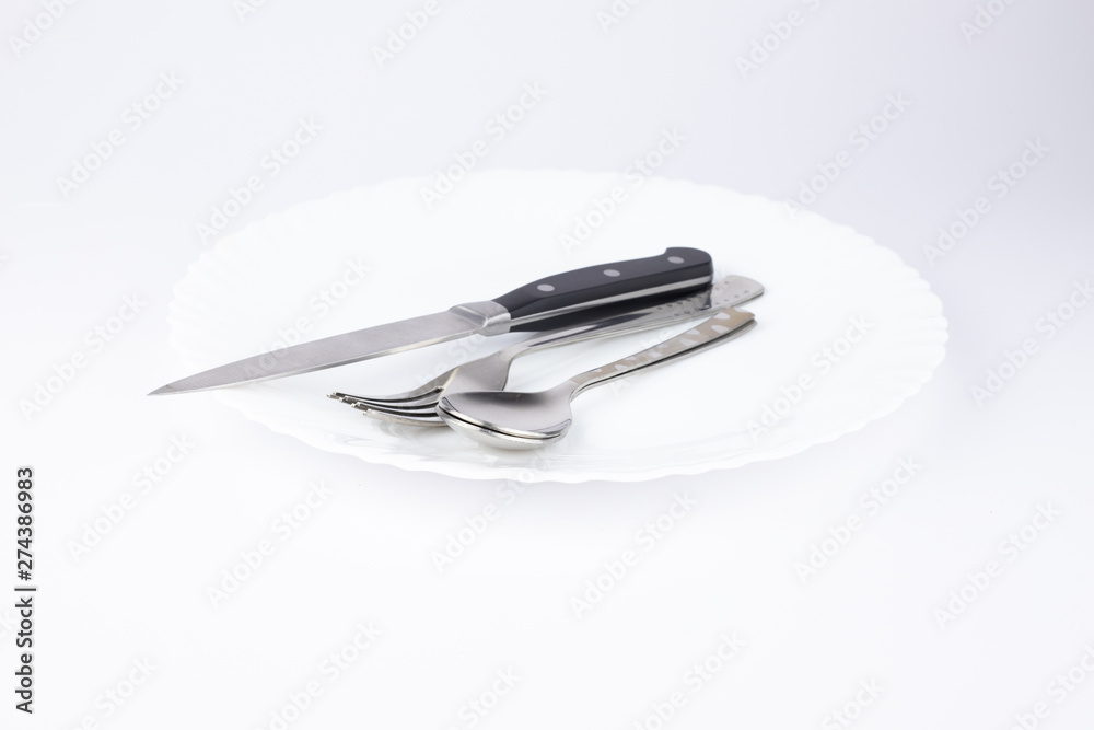 Empty white plate, spoon and knife isolated on white background. diet concept. Empty white plate, spoon and knife isolated on white background. diet concept.