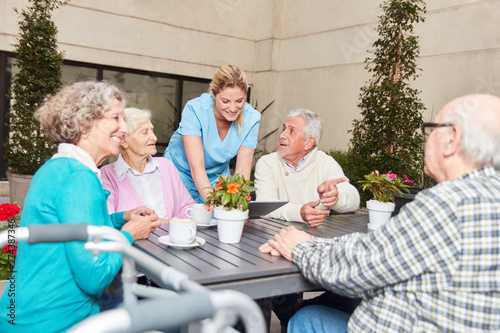 Group of seniors talking in retirement home