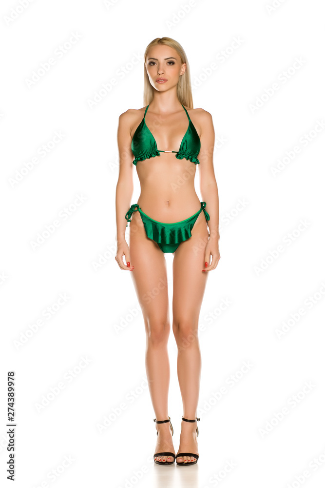 Pretty young lady in green bikini swimsuit and sandals on white background Pretty young lady in green bikini swimsuit and sandals on white background
