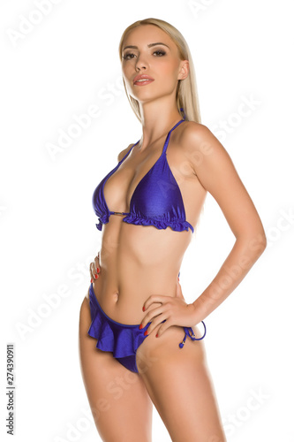 Pretty young lady in blue bikini swimsuit on white background