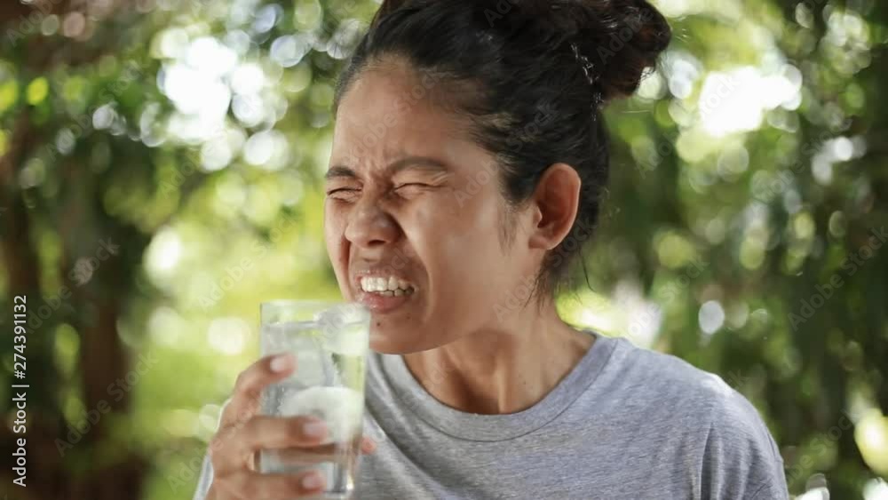 Young Asian woman with sensitive teeth, woman drinking cold drink Young Asian woman with sensitive teeth, woman drinking cold drink