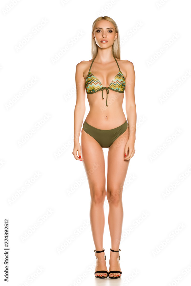 Pretty young lady in green bikini swimsuit and sandals on white background Pretty young lady in green bikini swimsuit and sandals on white background
