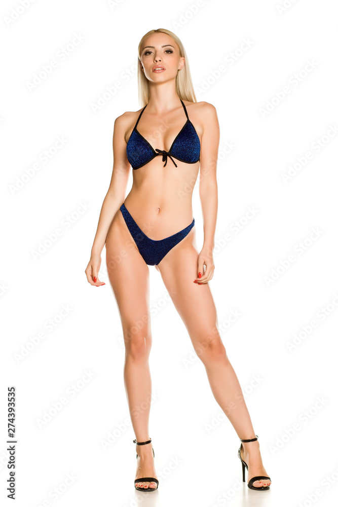 Pretty young lady in blue sparkling glitter bikini swimsuit and sandals on white background Pretty young lady in blue sparkling glitter bikini swimsuit and sandals on white background