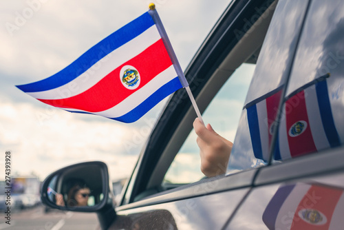 Woman or Girl Holding Flag of Costa Rica from the open car window. Concept