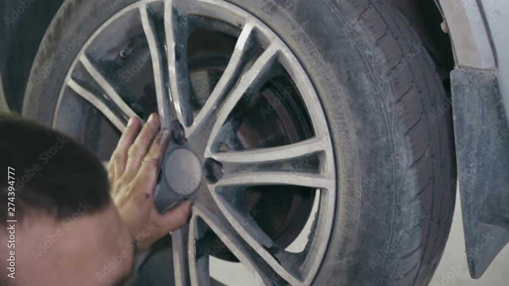Mechanic replaces repaired car wheel