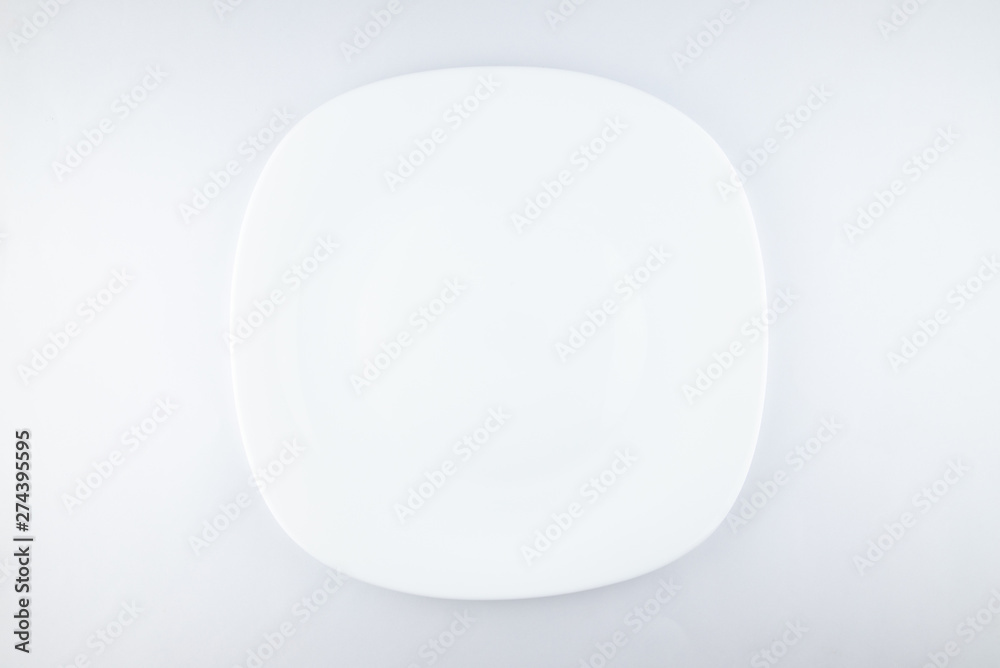 Empty white plate, spoon and knife isolated on jute background. diet concept. Empty white plate, spoon and knife isolated on jute background. diet concept.
