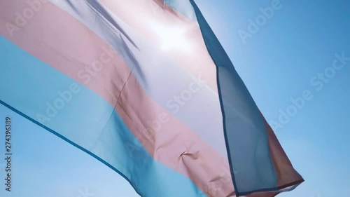 transgender pride flag waving on the blue sky