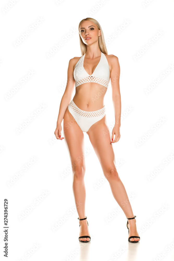 Pretty young lady in white swimsuit and sandals on white background Pretty young lady in white swimsuit and sandals on white background