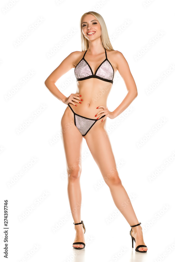 Pretty young lady in silver glittering swimsuit and sandals on white background Pretty young lady in silver glittering swimsuit and sandals on white background