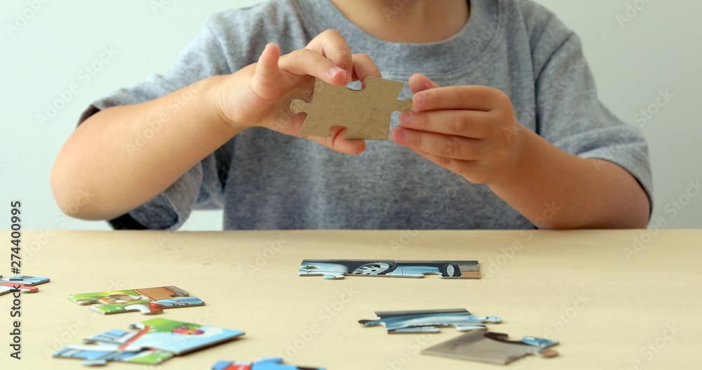 Puzzles. Baby hand fold puzzle closeup at table Puzzles. Baby hand fold puzzle closeup at table