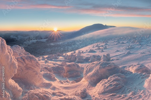 Beautiful winter panorama with fresh snow and hoarfrost. Landscape with spruce trees with sun light mountains on background Fantastic evening winter landscape. Dramatic colorful sky. Beauty world.