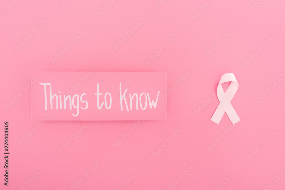 top view of card with things to know lettering and breast cancer sign on pink background top view of card with things to know lettering and breast cancer sign on pink background